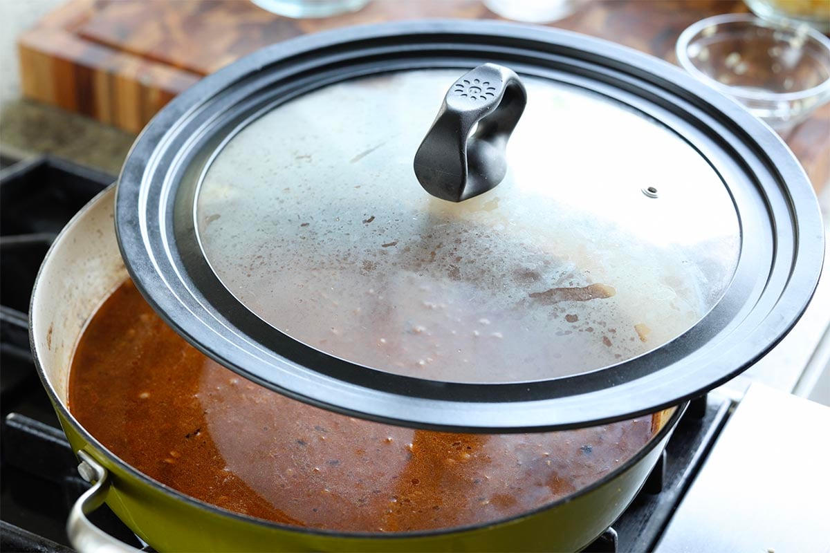 covering the pan with the lid to cook the lentils