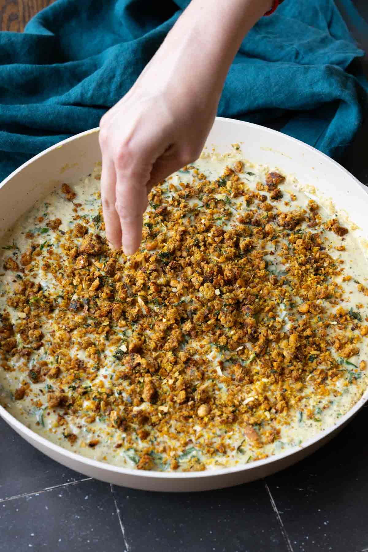 adding the chickpea crumble to the pepper beans